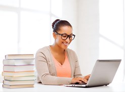Woman sitting at a desk with a stack of books